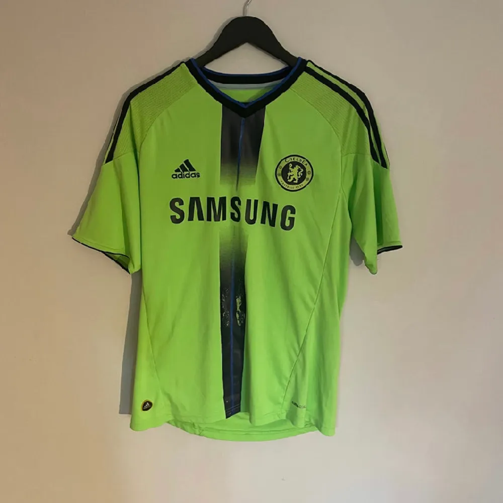Chelseas officiella tredjetröja från 2010 med Chelsea legenden Drogba #11 på ryggen. Tröjan är i grymt skick utöver en missfärgning strax under Samsung sponsorn.   Produktkod P00189. T-shirts.