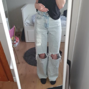 Högmidjade Zara jeans - Högmidjade med hål på knäna. Säljer pga inte min stil längre. Använda men ändå bra skick. Har dock lite småfläckar längst ner på benen som knappt syns, kanske går att tvätta bort. 