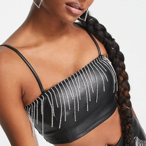 Bralette i läderimitation med strassfransar - PETITE - Petite Bralette i läderimitation från miss selfridge med strass 🖤 Oanvänd i originalförpackning med prislapp, säljes pga kommer ej till användning. 