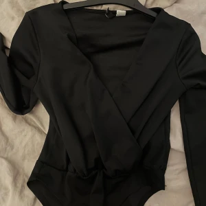 svart långärmad med detalj - denna bodyn som man knäpper nerifrån sitter som en smäck på kroppen, tveka inte på att höra av er vid intresse!!🥰