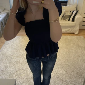 Topp med volang - Marinblå topp med volang, knappt använd! 