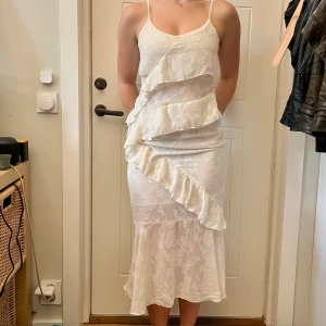 Klänning - Nyköpt, endast testad. Den är kräm-vit i nyansen och har fina volanger på framsidan. Sitter lite tajt på mig vilket är varför jag säljer den. Passar perfekt till finare tillställningar eller nu under sommaren. Hör gärna av dig om du har frågor🌸