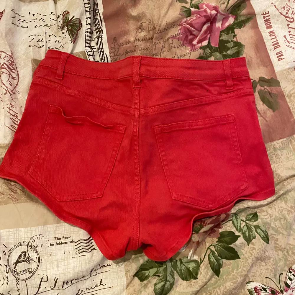 Röda korta shorts med slitningar i fram, finns i fler färger . Shorts.