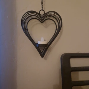 Hjärt ljushållare  - En hjärt ljushållare som är svart och man kan hänga på väggen. Ni får gärna ge prisförslag (Ljus ingår. Man får välja om man vill ha ett riktigt eller plastljus? 🤍🧿🌺