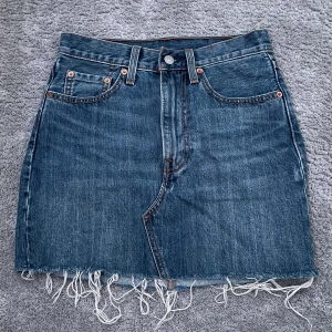 Mörkblå jeanskjol - Säljer denna jeanskjol från Levis som tyvärr är för små.  Längd: 40 cm Midjemått (rakt över) : 36 cm