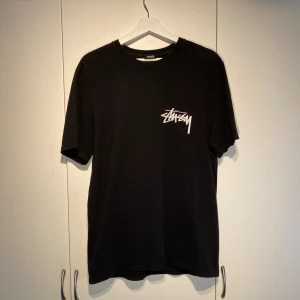 Stussy x Our Legacy Work Shop T-shirt Svart - Hej, säljer en sjukt snygg och populär t-shirt från Stussy’s samarbete med Our legacy, ”Work shop” kollektionen. Storlek M men passar L. Nypris runt 1200kr. Kvalitativ. Oversized. Pris kan diskuteras. Hörs i DM 