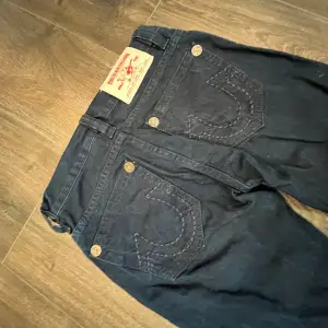 Jeans från true religion, dom är raka/lite utsvängda och Lågmidjade. Dom är mörk marinblå nästan svarta. Midjemåttet är 39 cm. Skriv innan ni köper!