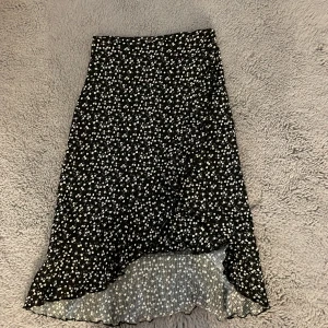 En lång kjol med mönster och slits - Bra skick, mönstrad svart kjol, vita blommor, en slits på sidan