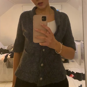 Kofta - En jättegullig kofta med korta ärmar. Den är blå med glitter och har superskraj knappar. Köpt här på Plick men är knappt använd. Inga defekter och skriv för fler bilder! Köparen står för frakten!!