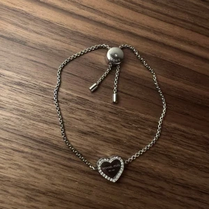 Michel kors armband hjärta silver - Fint justerbart armband från Michael kors med glittrande stenar runt.   