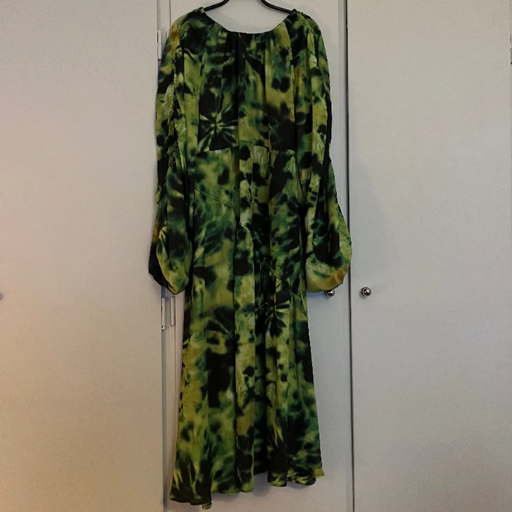 Grön mönstrad flowy klänning med snyggt urringad rygg Oanvänd med lappar kvar. Klänningar.