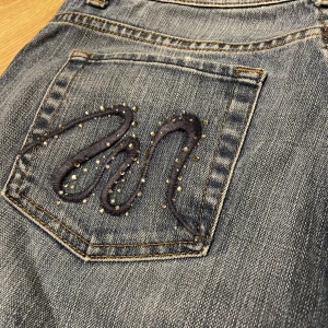 Bootcut jeans med broderade och rhinestones detaljer - Jätte fina bootcut aktiga jeans. Med fina detaljer på fickorna. 