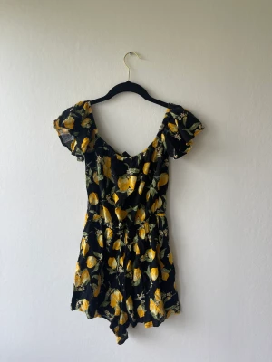 Byxdress från h&m - Fin byxdress med citroner på som kan användas som off-shoulder, storlek 36