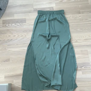 Lågmidjad satin långkjol - Super snygg lågmidjad grön långkjol. Superbra skick