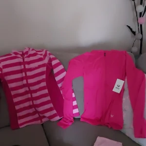 Två koftor - Den randiga koftan är mer för hösten och vintern,den mörk rosa liknande koftan är för tex gympan och lm du ska gå ut och jogga lite. Båda är nya så de är inte använda.