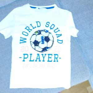 Två tröjor för åldern 6-7 en med fotboll och en haj surfing T-shirts 