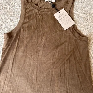 Brunt linne - Säljer mitt bruna linne från Dagmar. Linnet är helt k nyskick då prislappen fortfarande sitter kvar. Nypris -:699 kr säljer för -: 350 kr