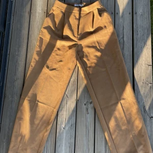 Kostymbyxor  - Bruna byxor från nakd i storlek 36, vida längs ned och något lång modell. Skriv för frågor✨