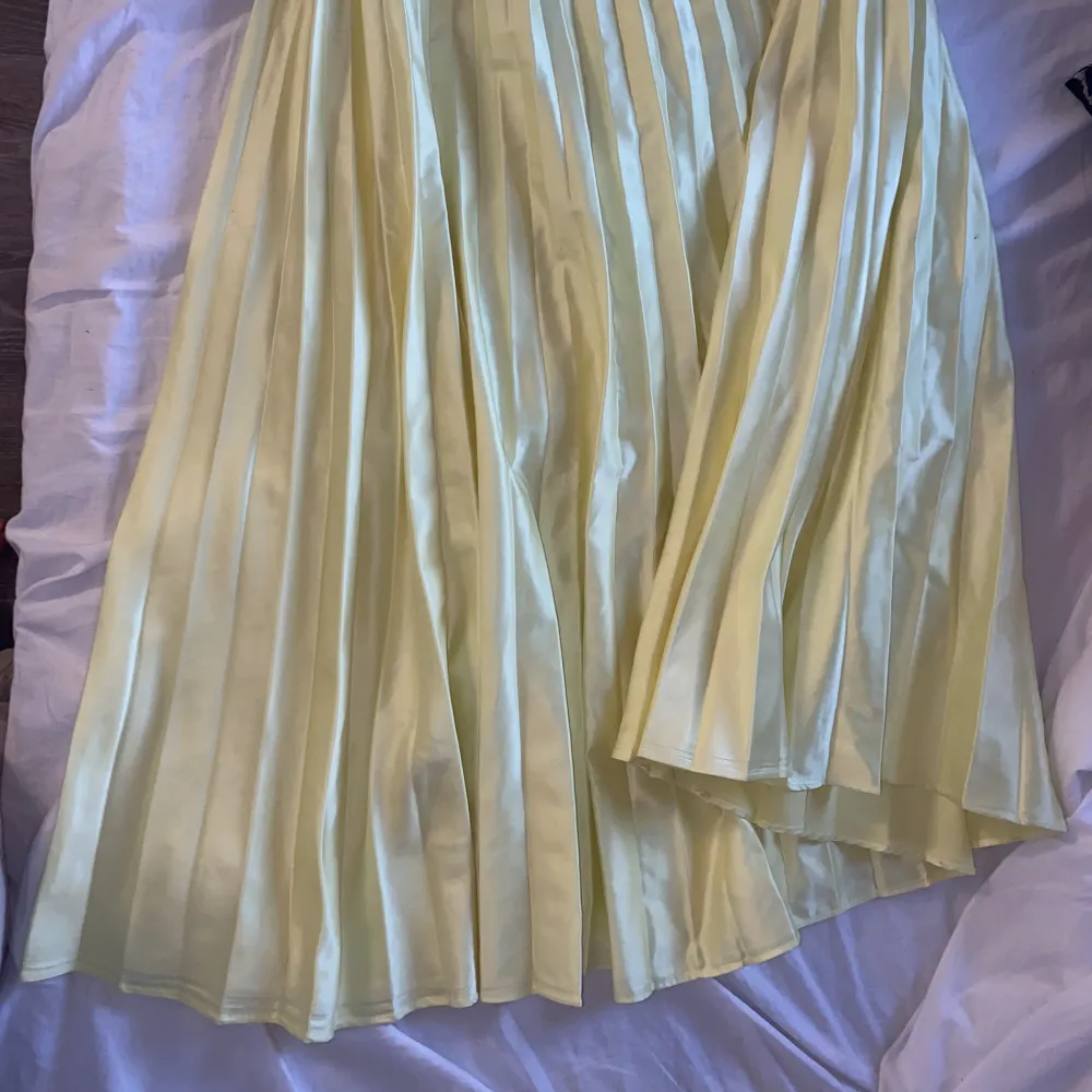 En fin plisserad kjol i satin ifrån zara, använd ett fåtal gånger, den är mycket gulare i verkligheten vilket är svårt att få på bild . Kjolar.