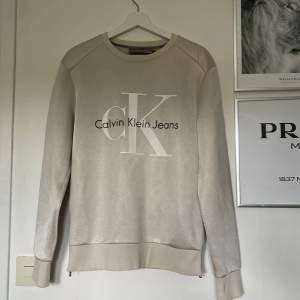 En Calvin Klein tröja i Polyester! Den har även 2 mindre kedjor vid båda sidorna! Size - Small