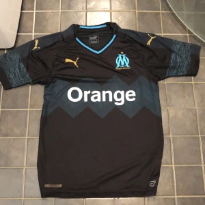 Marseille Fotbollströja - Marseille T-shirt Fotboll Storlek:S men som ni ser på bilden så passar den även på mig som har storlek M Superbra skick skulle säga att de vart min favorit T-shirt Skick:9/10