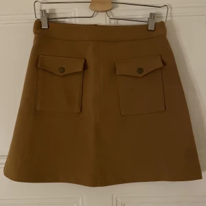 Kjol i senapsgul från H&M - Petit kjol i senapsgul från H&M i strl 36. Använd med i mycket gott skick! Fickor fram och dragkedja plus knapp bak.