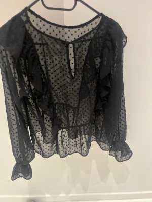 svart blus!           - Ett liten hål i armhålan. 