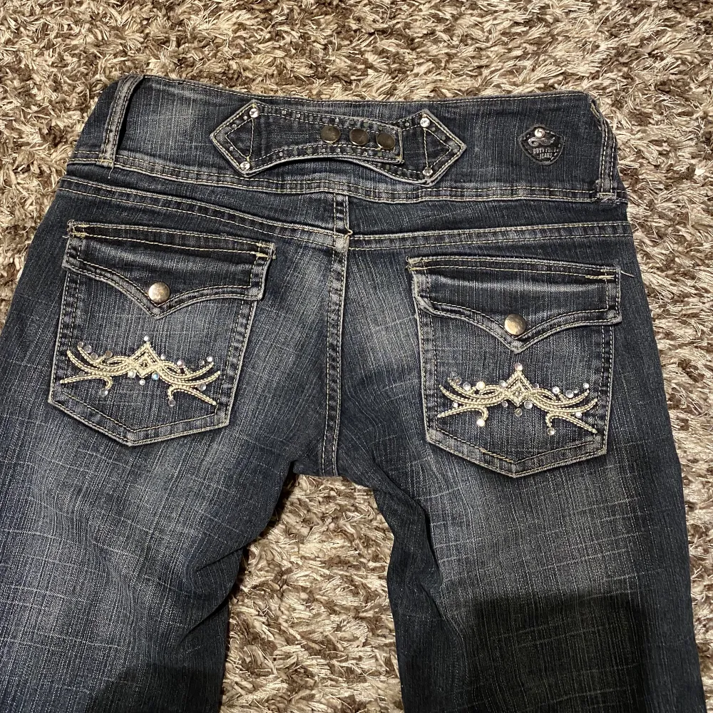 Utsvängda lågmidjade jeans med coola detaljer och knappar på fickorna.  Midjemått tvärs över: 36cm Innerbenslängd: 72cm . Jeans & Byxor.