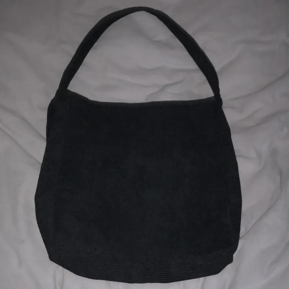 En svart väska med mycket plats, och fina detaljer med värde på 300 kr. Väskor.