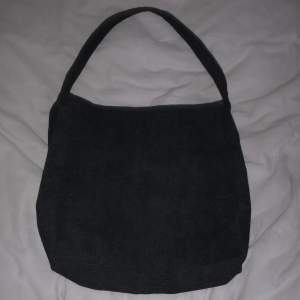 En svart väska med mycket plats, och fina detaljer med värde på 300 kr
