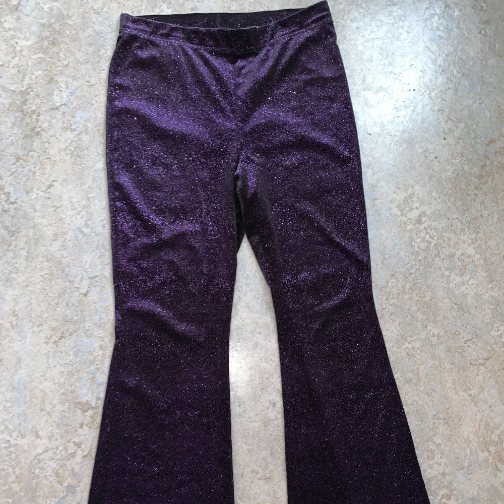 Ett par jättefina lila glittriga utsvängda byxor!💜 sitter superfint och bekvämt! (Byxorna är helt nya!). Jeans & Byxor.