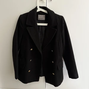  svart kappa mig guldknappar  -  Från Vera Moda