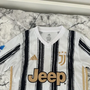 Juventus Home kit 20/21 - Juventus hemmatröja 20/21. Den är väldigt fin och sitter väldigt bra på kroppen. Passar både S/M. För 230 får du tröjan, för 250 kan du få både tröjan och shortsen till.