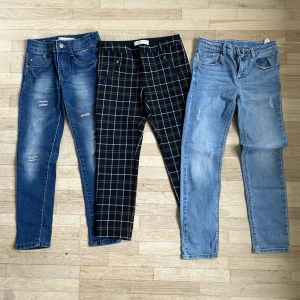 Barn byxor  - Tre par barn byxor i storlek 128. Två par jeans och ett par polyesterbyxor 