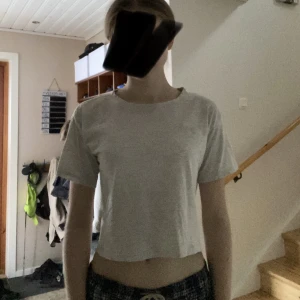 Vit/grå topp  - En vit/grå croppad t-shirt med NYC på framsidan från hm🤍Använd ca 5 gånger och har inga fel, förutom att underarmarna är lite missfärgade. Strl. 158/164 men kan passa som XS☺️