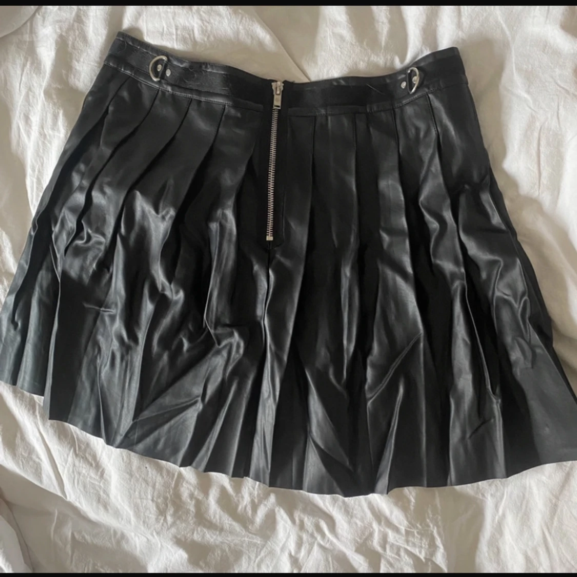 Plisserad kjol i skinnimitation med silverdetaljer - 90