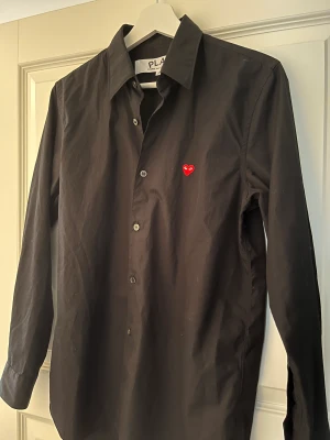 Cdg skjorta - Svart cdg play skjorta i storlek S. Använd 2 gånger. Nypris 2300, lägger ut för 999(pris kan diskuteras)