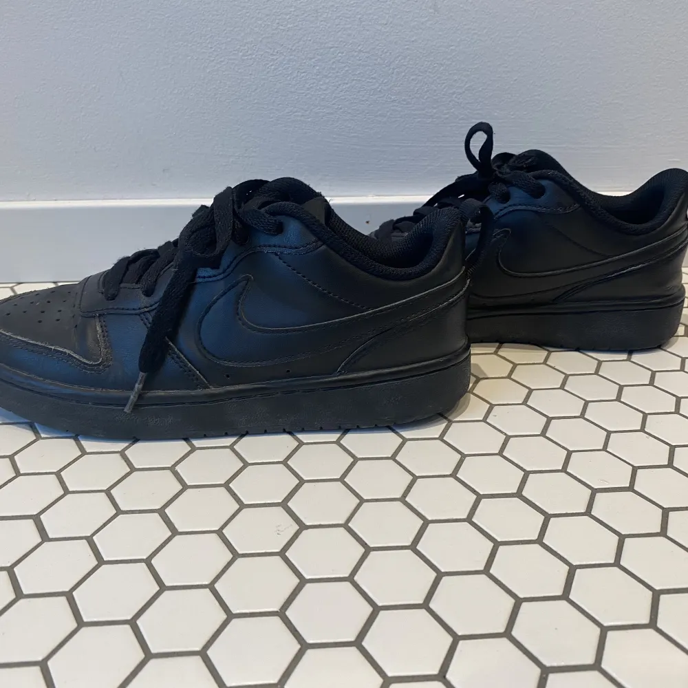 Ett par svarta Nike skor som inte är till användning längre. Dem är i ganska bra skick och inte smutsiga. Väldigt sköna skor att ha till skolan och gå mycket i.. Skor.
