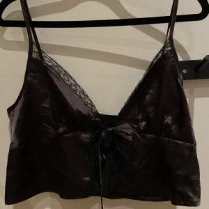 Svart topp - Jätte snygg topp, i spets och med knytning. I storlek M och är helt oanvänd pga att den inte passar. 