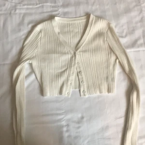 Vit sommar kofta  - - Plagg: Kofta/ bolero - Mönster: Inget - Färg: Vit/Creme  - Storlek: M - Märke: Shein - Skick: Väldigt Bra  - Egenskaper: Ribbad, knappad, tight ärmad, kort (kan användas som kofta eller vanlig crop top) Kontakta mig gärna vid frågor 💕 