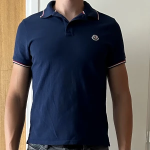 Mocler Pike M - Moncler Pike Marin blå, storlek Medium. Endast använd ett fåtal gånger, säljer den då jag har växt ur den. Nypris 2599 kr, kvitto från NK finns.