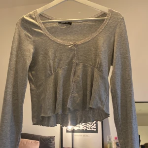 Grå tröja🩶 - En grå snygg tröja, lite urringad med rosett. Aldrig använt utanför hemmet💖 Dm för frågor eller prisförslag! Ny pris 259kr. 