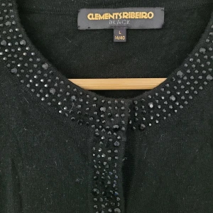 Clements Ribeiro - cardigan ull kashmir - Jättefin cardigan med strass i storlek 40/42 med bl.a ull och cashmere. Kommer från djur- och rökfritt hem. 33% viskos 23% nylon 20% bomull 20% lammull 4% kashmir