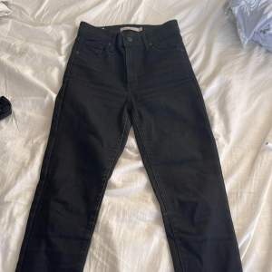 Levis jeans i high rise, svarta med storlek 25 i midjan, o 30 i benen. Sitter under naveln 