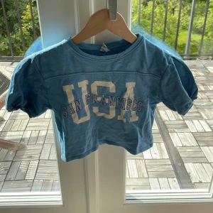 USA SAN Francesco topp - Blå topp med buff armar och tryck där det står: USA SAN FRANCISCO💙