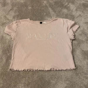 Rosa/lila croptop  - Rosa/lila croptop från HM . Använd några gånger . Tryck på tröjan där det står Malibu California 