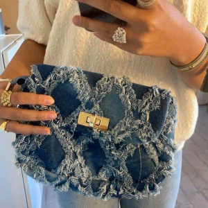 Denimväska - Väldigt fin väska i ”jeansmaterial”. Aldrig använd så i nyskick. Den har band som inte syns på bilden. Frakt ingår ej i priset.