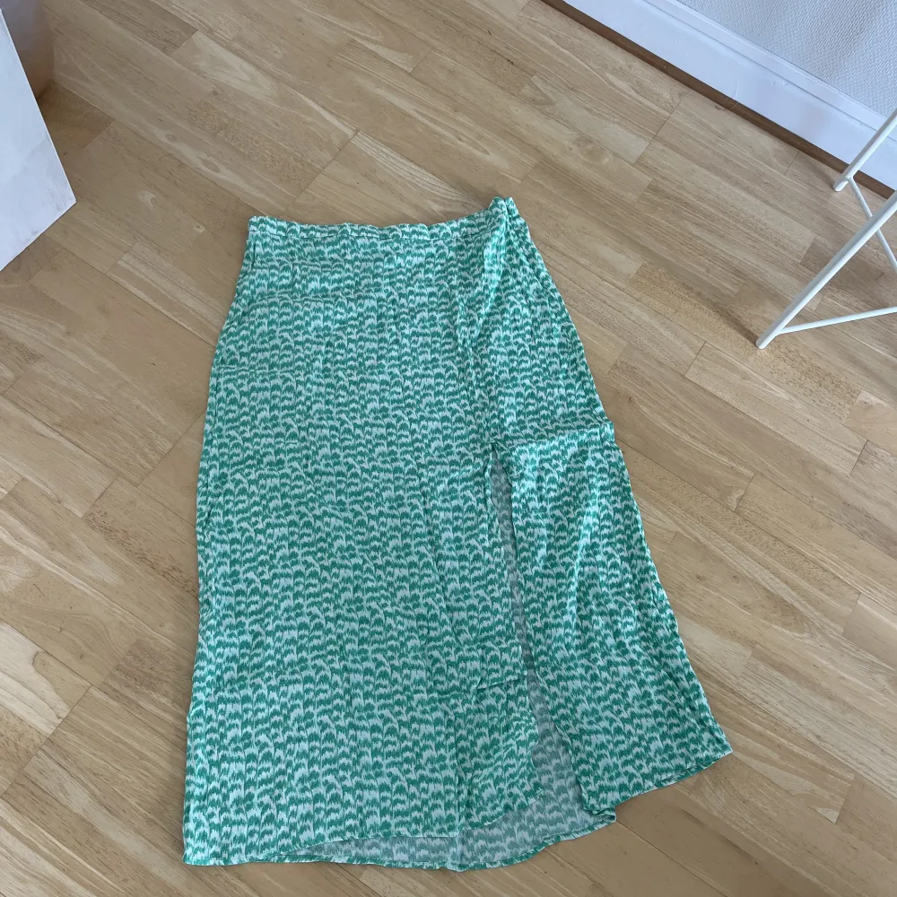 Skitsnygg grön mönstrad kjol med slits. Ifrån H&M, storlek 44. . Kjolar.
