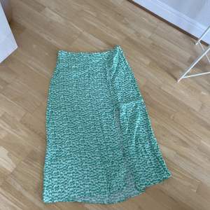 Skitsnygg grön mönstrad kjol med slits. Ifrån H&M, storlek 44. 