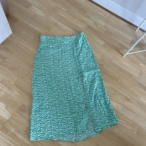 Grön mönstrad kjol - Skitsnygg grön mönstrad kjol med slits. Ifrån H&M, storlek 44. 